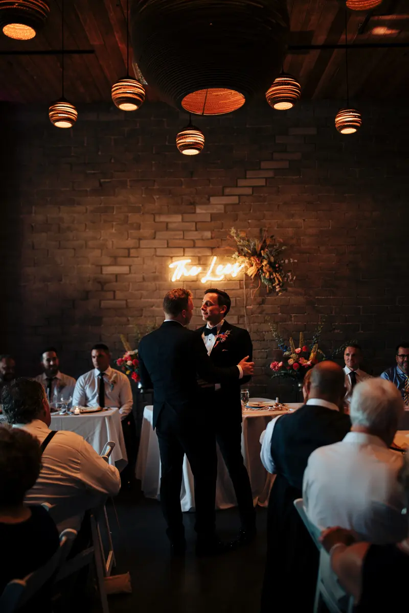 Two men dancing together at a wedding reception