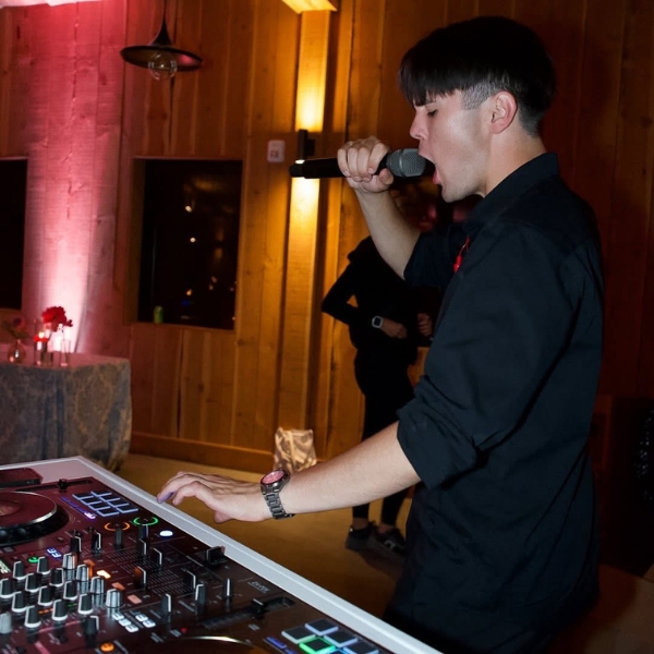 Image of a DJ with a microphone in his hand talking to the crowd at a private event in Seattle.